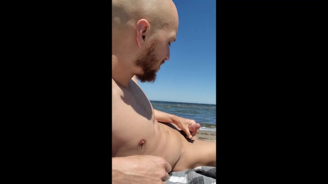 Brainwashed gooner boy strokes his cock on public beach