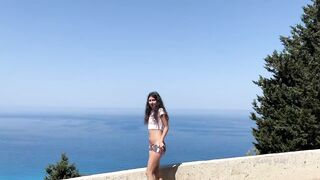 Shameless girl pissing standing on the background of the sea