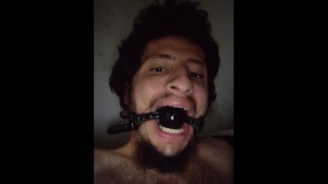 Gagged boy spitting in himself while wanking his big cock