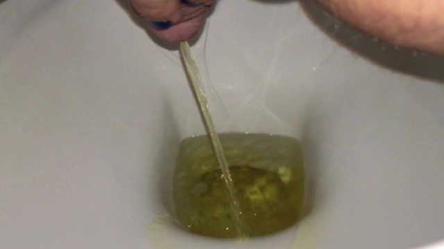Urination into the toilet with yellow urine