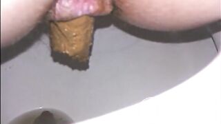 Woman shitting a long turd very slowly in the toilet