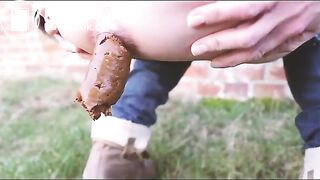 Mia poops outside a barn