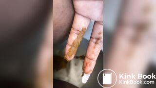 Ebony lady pushing pebbles into the toilet