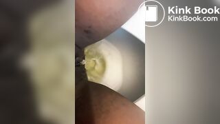 Ebony lady pushing pebbles into the toilet