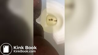 Ebony lady pushing pebbles into the toilet
