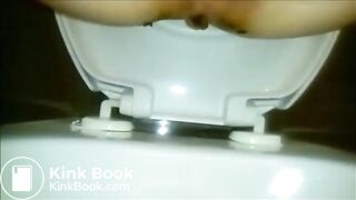 Woman shitting a long turd in the toilet