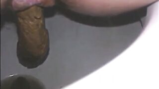 Woman shitting a long turd very slowly in the toilet