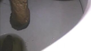 Woman shitting a long turd very slowly in the toilet