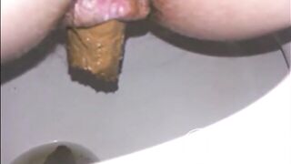 Woman shitting a long turd very slowly in the toilet