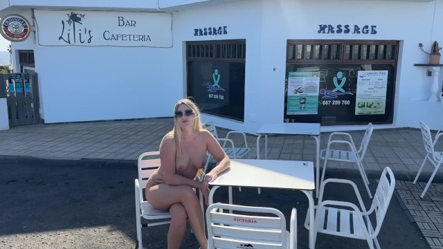 girl sitting naked in a cafe in public