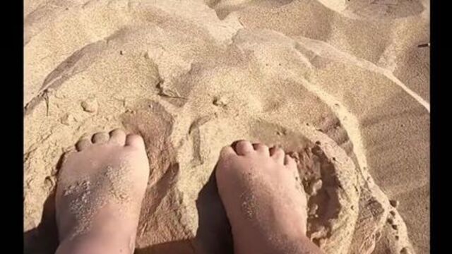 Provocative feet play in the sand, in public.