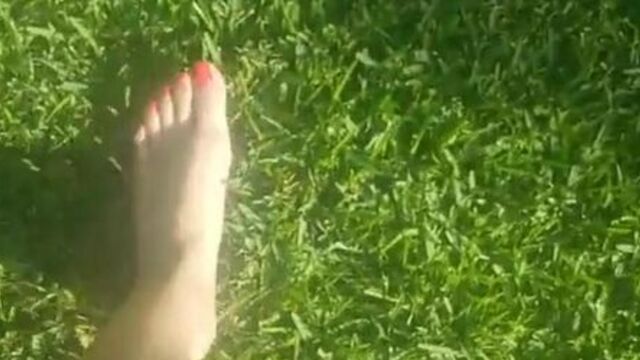 Sexy barefoot teen walks through grass