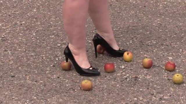 Crush fetish outdoors. Fat legs in high heel shoes crush apples.