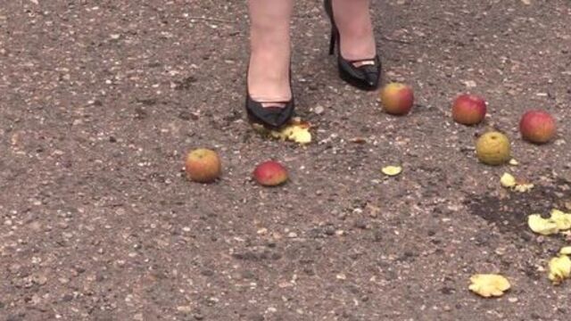 Crush fetish outdoors. Fat legs in high heel shoes crush apples.