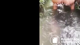 asian shitting in water stream