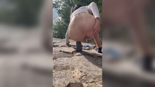 Cute girl outdoor shitting on the rocks