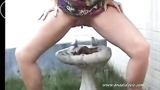 blonde girl pooping in her garden
