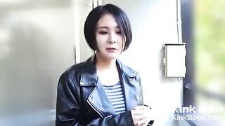 Asian woman in leather jacket pooping