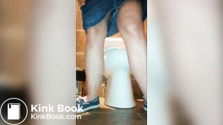Woman shitting public toilet at restaurant.